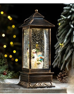 Detail of a vintage bronze Christmas lantern with snowmen inside and warm bokeh lights