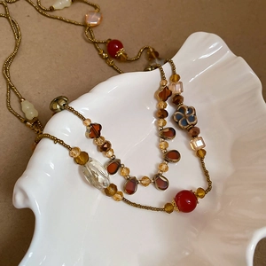 Gros plan d'un collier bohème perlé avec gouttes d'ambre et fleurs en céramique