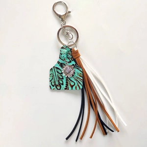 Detailed view of western style keychain with leather tassels and sunflower charm