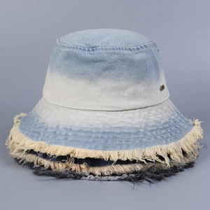 Detailed close-up of frayed denim edges and textured gradient blue bucket hat