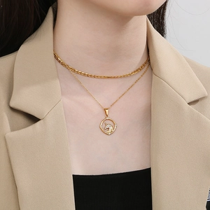 Detail view of double-layer gold necklace with sparkling rhinestone unicorn pendant