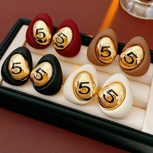 Detail of drop-shaped earrings with matte finish and gold number five engraving