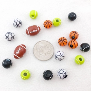 Mix of acrylic sports beads like basketball and football with a coin for size reference