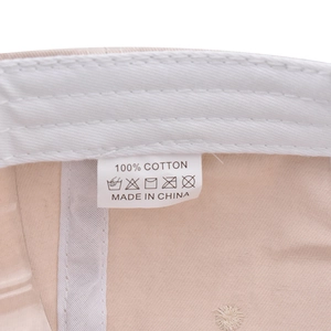 Close-up of internal wash label on 100% cotton baseball cap showing material details