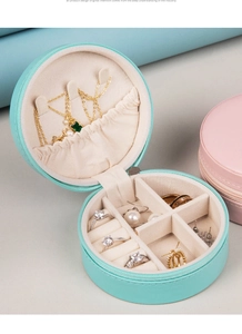 Detail view of mint green round travel jewelry box with multiple functional compartments