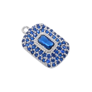 Macro shot of silver pendant with rectangular blue center stone and pave setting