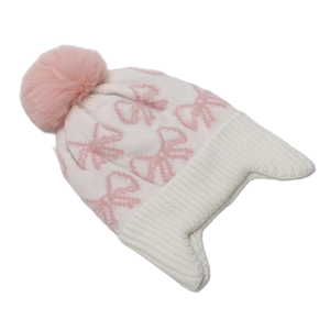 Dettaglio del cappello invernale in maglia da bimba con fiocco rosa e pompon in eco-pelliccia