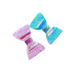 Sparkly pink and blue bow hair clips with holographic center on a clean white background