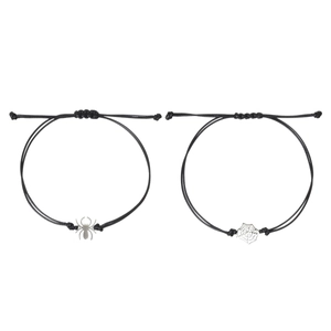 Detail of adjustable black cord bracelets featuring silver spider and web charms for couples