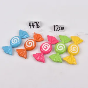 Close-up of five colorful candy lollipop ornaments with white glitter swirls for Christmas trees