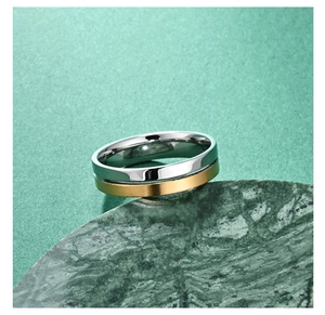 Detailed close-up of a two-tone stainless steel couple's ring on a green marble display