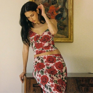 Detailed close-up of a floral V-neck top and skirt set with a red rose print design
