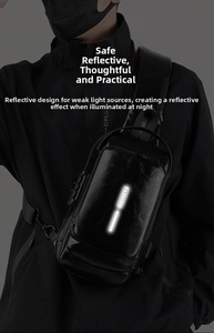 Detail view of the vertical reflective safety strip on a black leather chest bag
