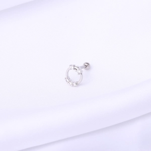 Macro shot of a hollow round stud earring with cubic zirconia on white fabric
