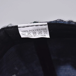 Detail of internal wash label showing 100% polyester material and care icons on baseball cap
