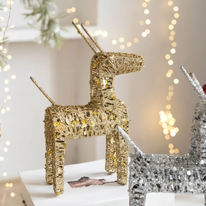 Golden and silver Christmas reindeer decorations with glitter finish on festive background