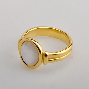 Macro view of oval white mother-of-pearl inlay on 18K gold plated double band ring