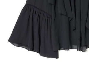 Detail of multi-layered ruffled hem on a black chiffon blouse for women