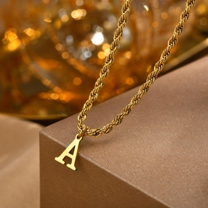 Detail of gold-plated stainless steel rope chain with a minimalist letter A pendant
