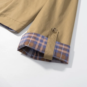 Detail of khaki jacket cuff featuring plaid lining and adjustable button strap