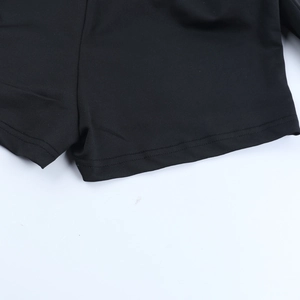 Macro detail of the double-stitched hem and fine elastic fabric on black casual shorts