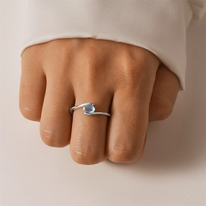 Detailed close-up of S925 silver ring featuring an oval blue zircon on a finger
