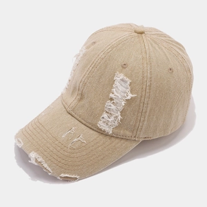 Detail der gewaschenen Baseballkappe in Sandfarbe mit ausgefransten Kanten und Vintage-Textur