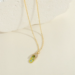 Golden necklace with green sandal pendant featuring evil eye motifs and sparkling crystals