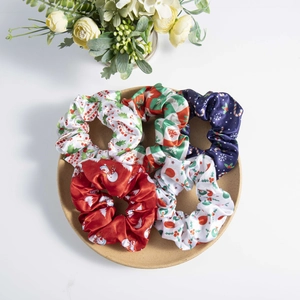 Set of five festive Christmas satin scrunchies featuring colorful snowflake and snowman prints