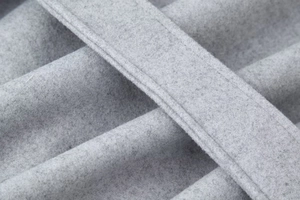 Macro de la texture du tissu en laine grise et des coutures sur un manteau d'hiver