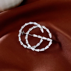 Macro shot of silver-plated interlocking G brooch set with baguette-cut white zircons
