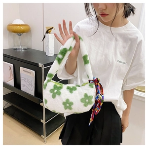 Close-up of fluffy white faux fur handbag with green flower patterns and silk scarf