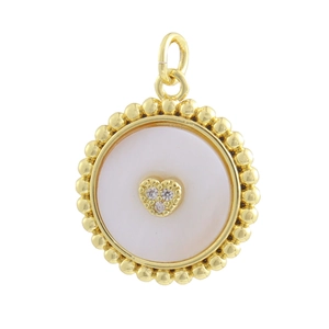 Detail of round gold pendant with white shell inlay, beaded edge and heart crystal