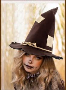 Detail of suede scarecrow witch hat with burlap rope and rustic patches for Halloween