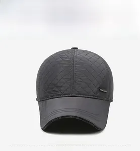Detail of dark grey quilted baseball cap with metal logo and fashion brim print