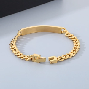 Detail of golden stainless steel curb chain bracelet with polished curved bar and roman numbers