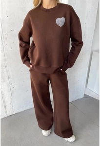 Close-up of brown crewneck sweatshirt with heart fingerprint print and drawstring pants
