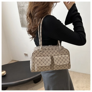 Detailed shoulder view of a beige monogrammed underarm bag with double strap design