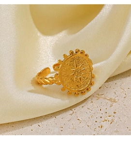 Detail of 18K gold starburst ring with hammered texture and beaded edge on silk