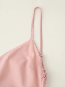 Gros plan détaillé des bretelles en satin rose avec boucles métalliques et coutures fines