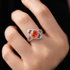 Elegant halo ring with oval orange zircon and white accents on silver band