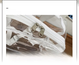 Detail view of the polished silver double metal zippers on the transparent PVC beach bag