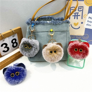 Close-up of four colorful plush cat ball keychains with soft faux fur and metal hooks