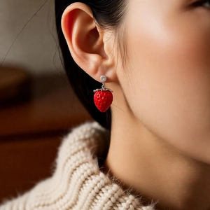 Close-up of elegant red strawberry earrings with silver hardware and small zircon stones