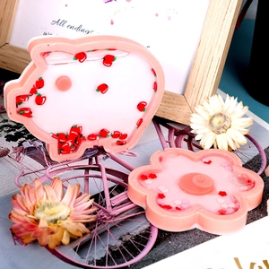Detalle de molde de silicona de cerdo y flor rosa con lentejuelas de manzana roja