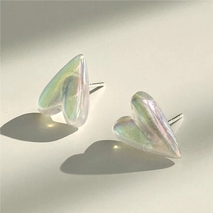 Macro detail of irregular heart earrings with aurora pearlescent finish and silver pins