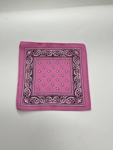 Detail of pink cotton paisley bandana with stitched edges and classic white floral patterns