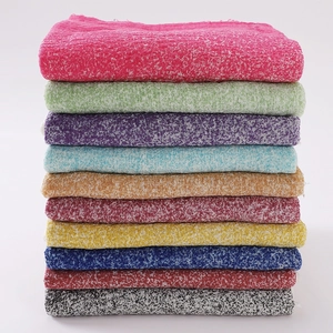 Detailed stack of woven cotton linen scarves in ten vibrant tie-dye gradient colors