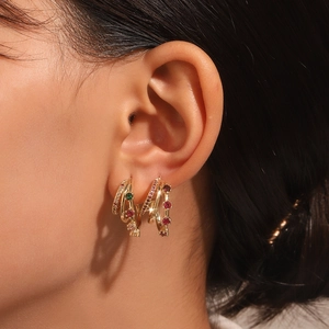 Detail of gold multi-layer C-shaped earrings with colorful zircon stones on model