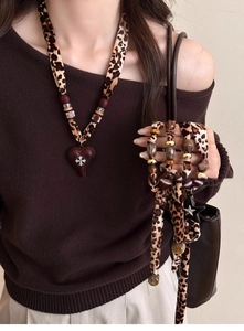 Detailed view of leopard print fabric necklace with heart pendant and star charms set